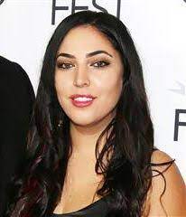 Hila Cage coppolo in a cute smile by wearing black dress.